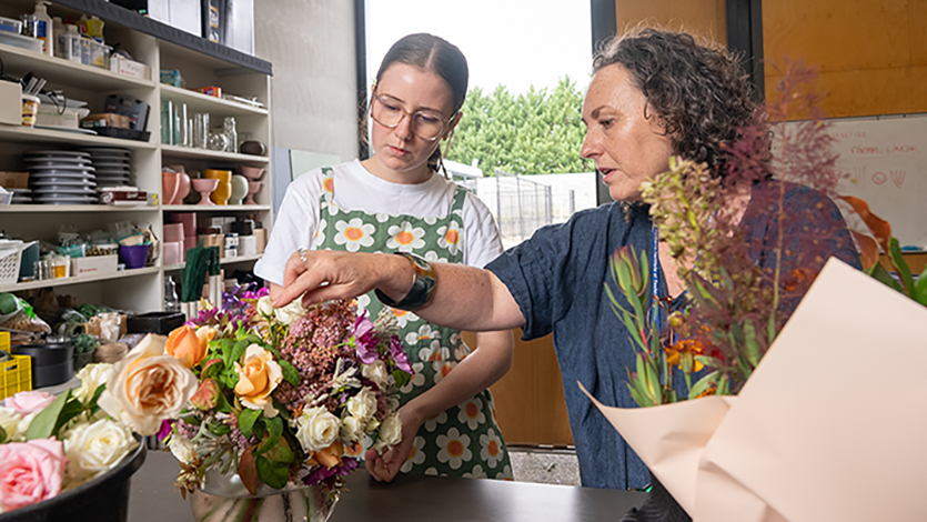Teacher and student arranging flowers