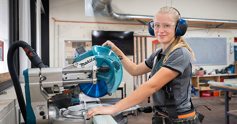 Abby CIT Carpentry student using a wood saw