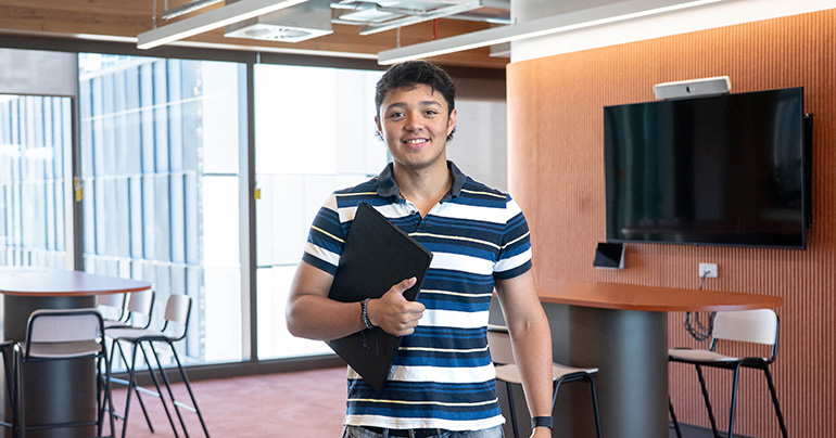 student standing with laptop